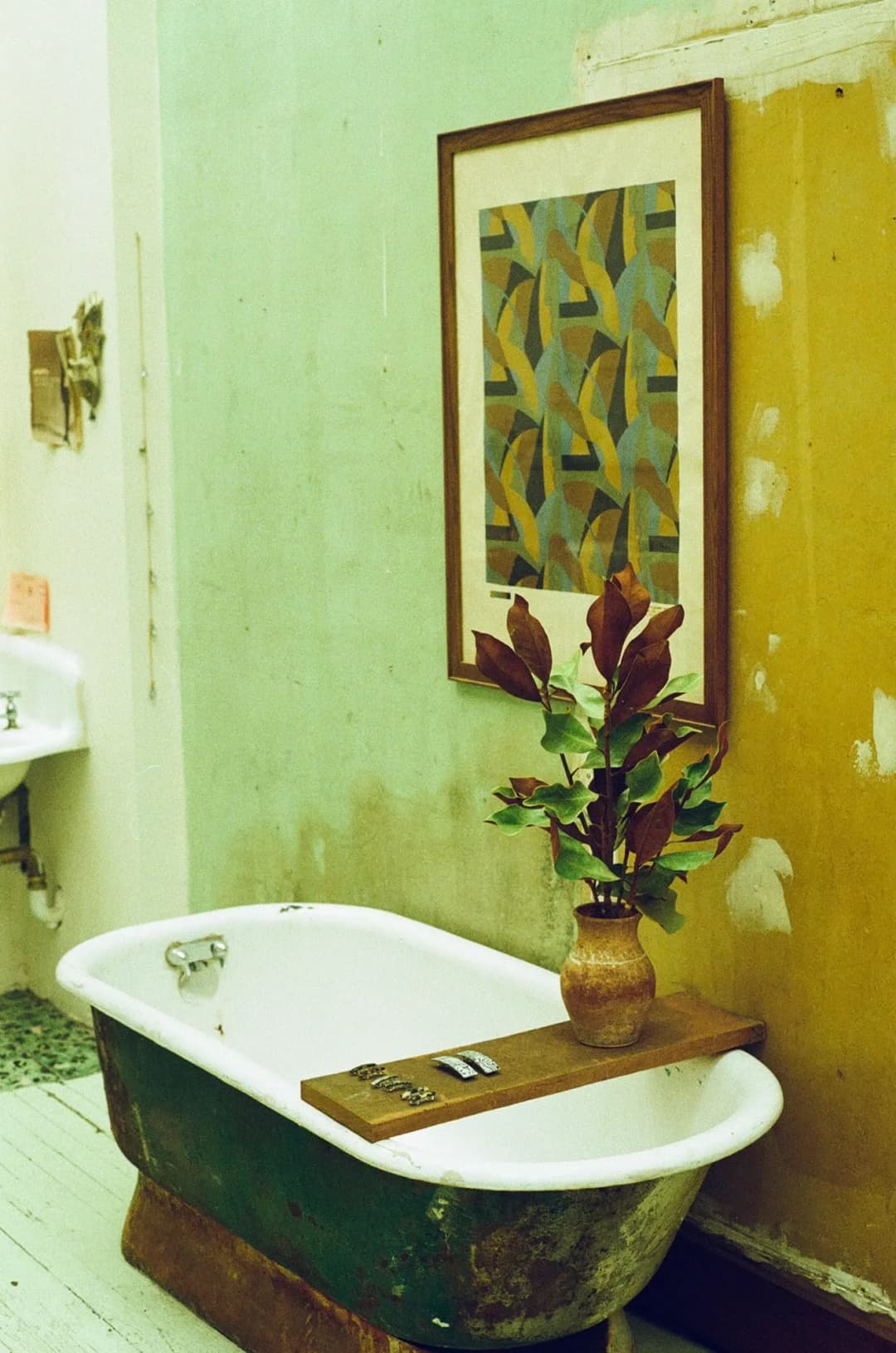 woman wearing an orange bikini sitting next to a basket of oranges against a wall and tossing an orange into the air